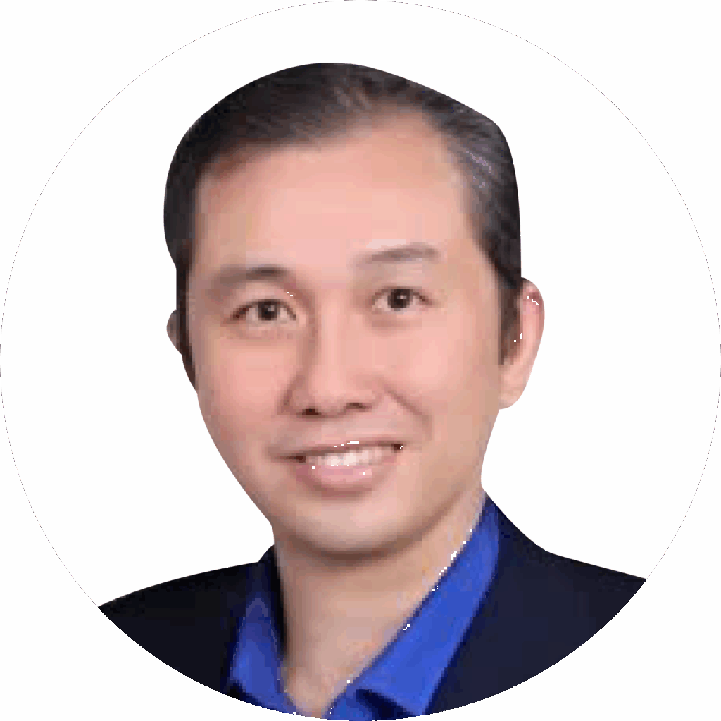 Tom Koh - Smiling East Asian man in a blue shirt and dark blazer, professional headshot.